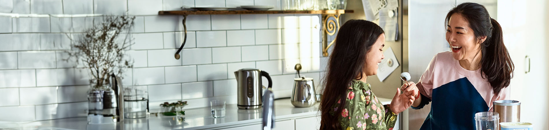 Mujer asiática con una niña en una cocina