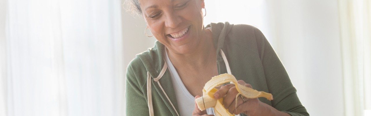 mujer rebanando un plátano