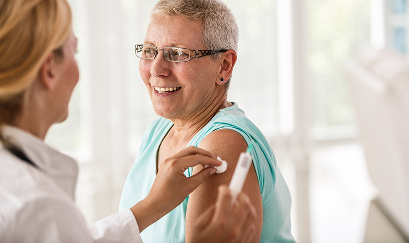 Una mujer mayor recibe una vacuna en el consultorio del médico.