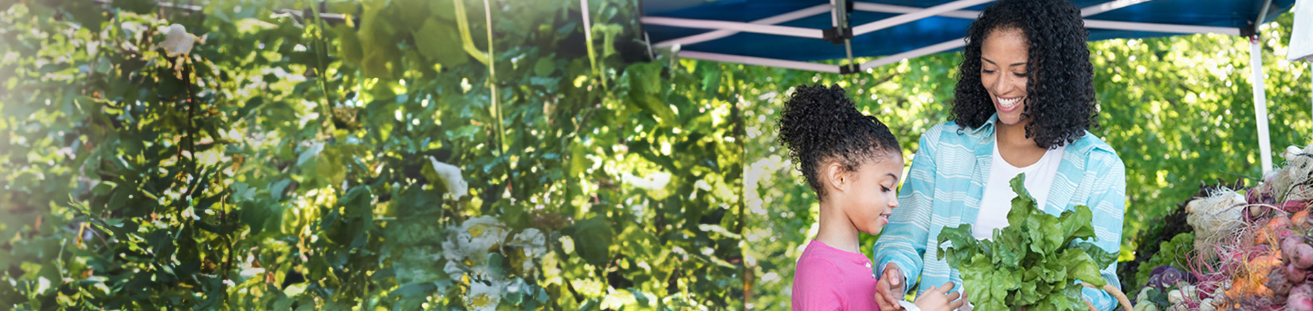 Mujer afroamericana con un hijo en el mercado agrícola