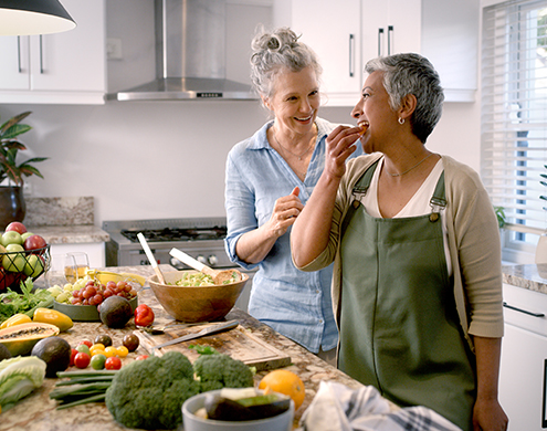 Dos adultos mayores cocinando comidas saludables en la cocina